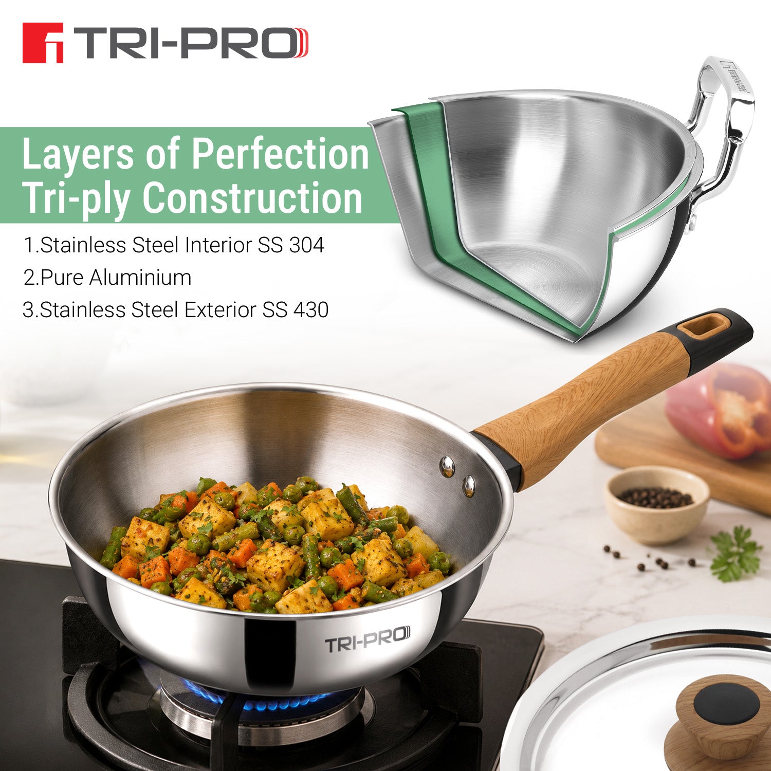 Tri-Pro 22cm/2L tri-ply stainless steel wok with wooden soft-touch handle on a gas stove, featuring a 3-ply layer diagram: SS 304 interior, aluminium core, and SS 430 exterior 