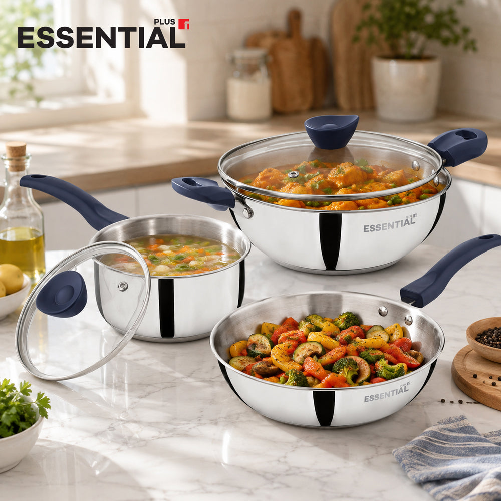 Three stainless steel cookware pieces with dark blue handles and lids are arranged on a marble kitchen counter. The set includes a deep saucepan with a glass lid, a medium saucepan with a glass lid, and a frying pan, all shown with food inside.